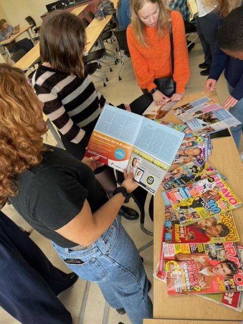 Students in classroom looking at magazines