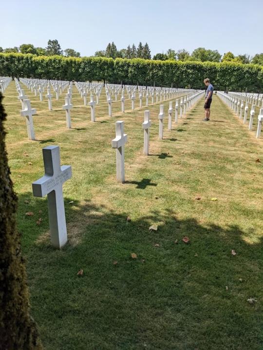 Man looking at headstone in a cemetery